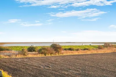 a plowed field with the ocean in the background at 1 Bed in Orford oc-m34121 in Orford