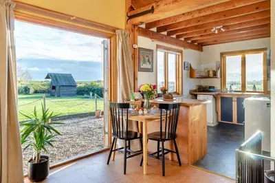 a kitchen with a table and chairs and a large window at 1 Bed in Orford oc-m34121 in Orford