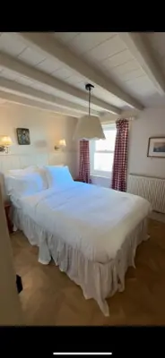 a large white bed in a room with a window at Sunray House - Sea View, Beach Front Holiday Home in Felixstowe