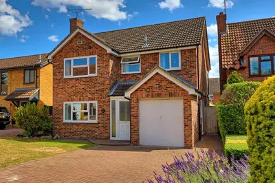 a brick house with a white garage at Premium 5-Bed Home, Garden, Parking & High-Speed Wi-Fi in Nevendon