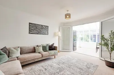 a living room with a couch and a sliding glass door at Premium 5-Bed Home, Garden, Parking & High-Speed Wi-Fi in Nevendon