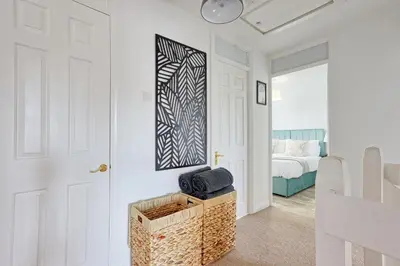 a white hallway with a room with a bed at Premium 5-Bed Home, Garden, Parking & High-Speed Wi-Fi in Nevendon