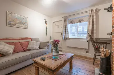 a living room with a couch and a coffee table at Charming Georgian flint cottage in Bury Saint Edmunds