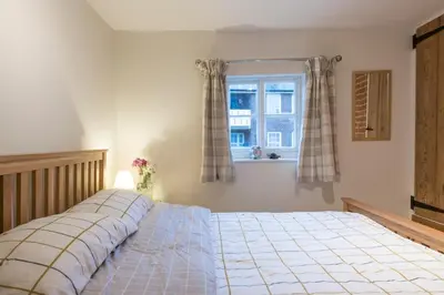 a bedroom with a bed and a window at Charming Georgian flint cottage in Bury Saint Edmunds