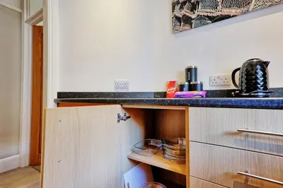 a kitchen with a counter and a counter top at Cosy 2 Bedroom Flat Near Westcliff On Sea Beach & Hamlet Court Road in Southend-on-Sea