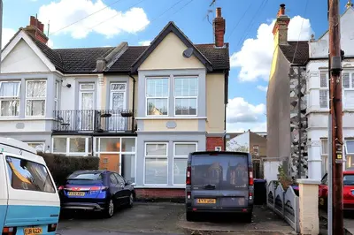 a van parked in a parking lot in front of a house at Cosy 2 Bedroom Flat Near Westcliff On Sea Beach & Hamlet Court Road in Southend-on-Sea