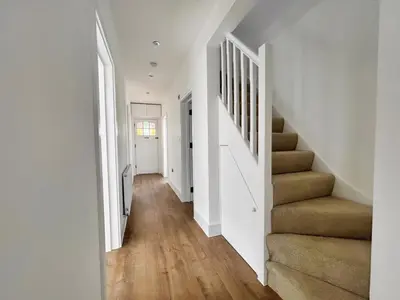 a hallway with white walls and stairs in a house at Green Rig