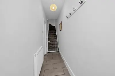 a hallway with white walls and a stairway at 17 OutRisbygate St - 3 bedroom house that sleeps 6 with one private parking space in Bury Saint Edmunds