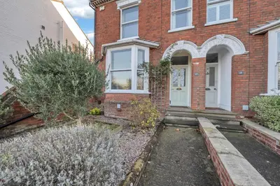 a brick house with a white door and windows at 17 OutRisbygate St - 3 bedroom house that sleeps 6 with one private parking space in Bury Saint Edmunds