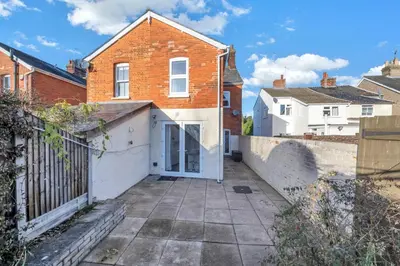 a brick house with a gate and a driveway at 17 OutRisbygate St - 3 bedroom house that sleeps 6 with one private parking space in Bury Saint Edmunds