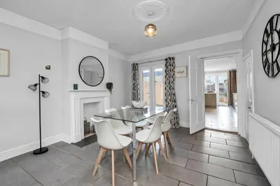 a dining room with a table and chairs and a fireplace at 17 OutRisbygate St - 3 bedroom house that sleeps 6 with one private parking space in Bury Saint Edmunds