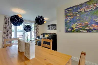 a dining room with a table and a painting on the wall at Modern House with Free Parking & Superfast WiFi in Cambridge