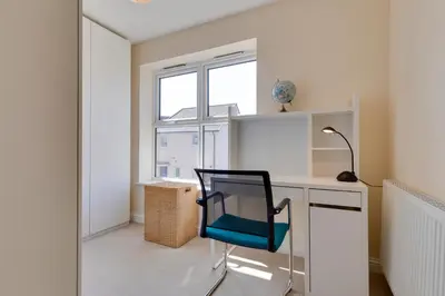 a desk with a chair in a room with a window at Modern House with Free Parking & Superfast WiFi in Cambridge