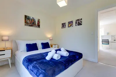 a bedroom with a large bed with blue sheets at Modern House with Free Parking & Superfast WiFi in Cambridge