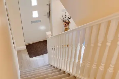 a staircase with white railings in a home at Modern House with Free Parking & Superfast WiFi in Cambridge