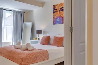a bedroom with a bed with orange pillows at Modern House with Free Parking & Superfast WiFi in Cambridge