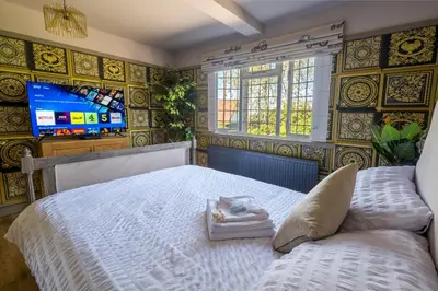 a bedroom with a white bed and a tv at Sampford Hideaway Retreat in Great Sampford