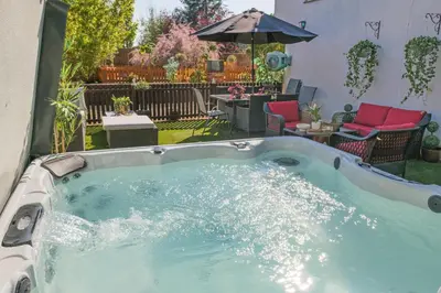 a jacuzzi tub in the backyard of a house at Sampford Hideaway Retreat in Great Sampford