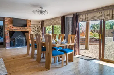 a dining room with a table and chairs and a fireplace at Sampford Hideaway Retreat in Great Sampford