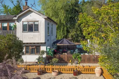 a white house with a fence in front of it at Sampford Hideaway Retreat in Great Sampford