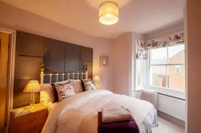 a bedroom with a large bed and a window at 3 bed Victorian terrace 10mins walk from Colchester city centre in Colchester