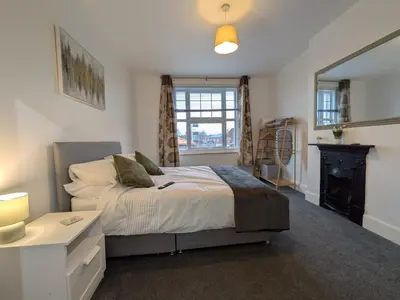 a bedroom with a bed and a fireplace and a window at Digby House flat 1 in West Mersea