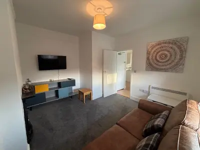 a living room with a couch and a flat screen tv at Digby House flat 1 in West Mersea