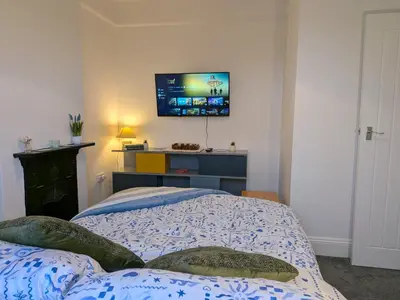 a bedroom with a bed with a tv on the wall at Digby House flat 1 in West Mersea