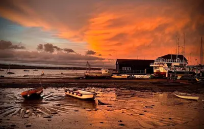 a group of boats sitting on the beach at sunset at Digby House flat 1 in West Mersea