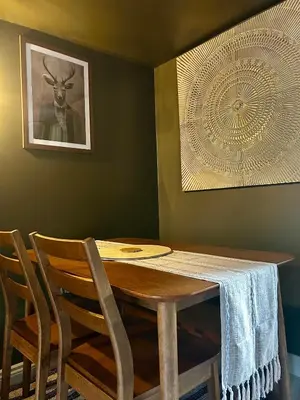 a dining room table with chairs and a picture of a deer at Daisy Cottage - Framlingham in Framlingham
