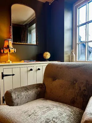 a living room with a couch and a mirror at Daisy Cottage - Framlingham in Framlingham