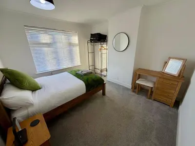 a bedroom with a bed and a desk and a mirror at City Centre, En-Suite, 3 Doubles 1 Single, 2 Car Parking in Colchester