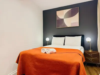 a bedroom with a bed with an orange blanket at Lux 2 Bedroom Flat Central Brentwood slp 8 Guests in Brentwood