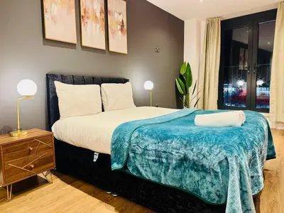a bedroom with a bed with a blue blanket on it at Lux 2 Bedroom Flat Central Brentwood slp 8 Guests in Brentwood