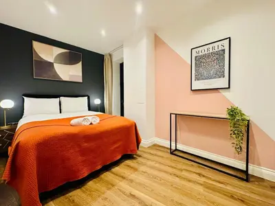 a bedroom with a bed with an orange blanket at Lux 2 Bedroom Flat Central Brentwood slp 8 Guests in Brentwood