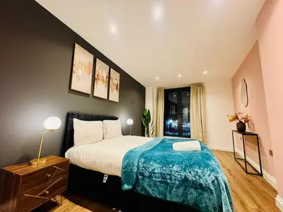 a bedroom with a large bed with a blue blanket at Lux 2 Bedroom Flat Central Brentwood slp 8 Guests in Brentwood
