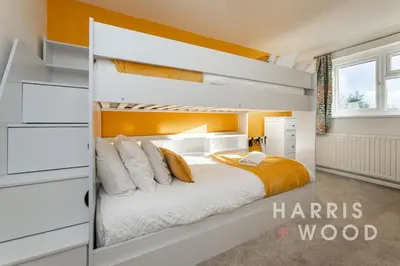 a bedroom with a bunk bed with an orange wall at Vine Cottage in Chelmondiston