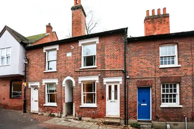 an old brick house with a blue door at Cottage in the centre in Colchester
