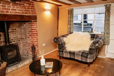 a living room with a couch and a fireplace at The Cotswold Luxe Cottage in Framlingham
