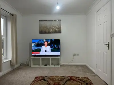 a living room with a flat screen tv on a wall at Chartsworth 4 Bedrooms Spacious House in Harold Wood