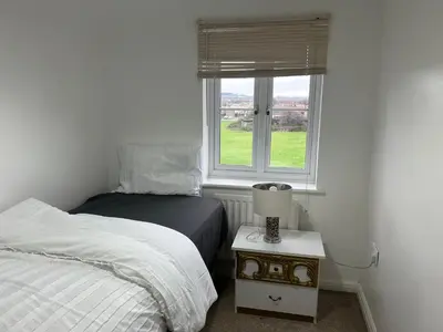 a bedroom with a bed and a window at Chartsworth 4 Bedrooms Spacious House in Harold Wood
