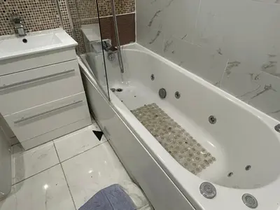 a white bathroom with a tub and a sink at Chartsworth 4 Bedrooms Spacious House in Harold Wood