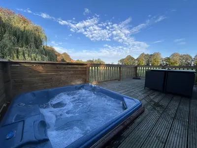 a jacuzzi tub on a wooden deck at Athelington Lodge - Chestnut in Eye