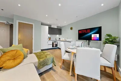 a living room and kitchen with a bed and a table at Modern, Quiet & Cozy Flat in Central Chelmsford - F7 in Chelmsford