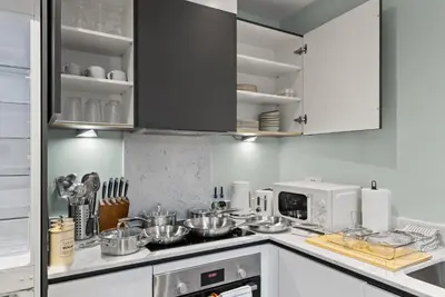 a kitchen with white cabinets and stainless steel appliances at Modern, Quiet & Cozy Flat in Central Chelmsford - F7 in Chelmsford