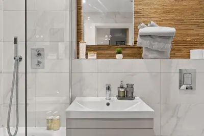 a white bathroom with a sink and a shower at Modern, Quiet & Cozy Flat in Central Chelmsford - F7 in Chelmsford