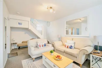 a living room with two chairs and a table at Seaside Luxury Cottage Aldeburgh in Aldeburgh