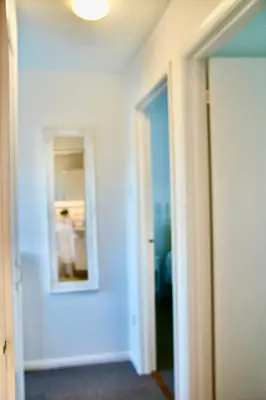 a white room with a mirror and a hallway at Seaside Luxury Cottage Aldeburgh in Aldeburgh