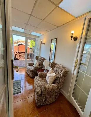 a living room with two chairs and a table at Three Bees in Hythe