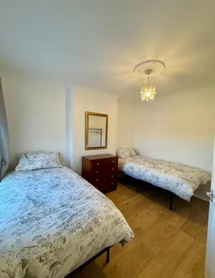 a bedroom with two beds and a mirror at Three Bees in Hythe